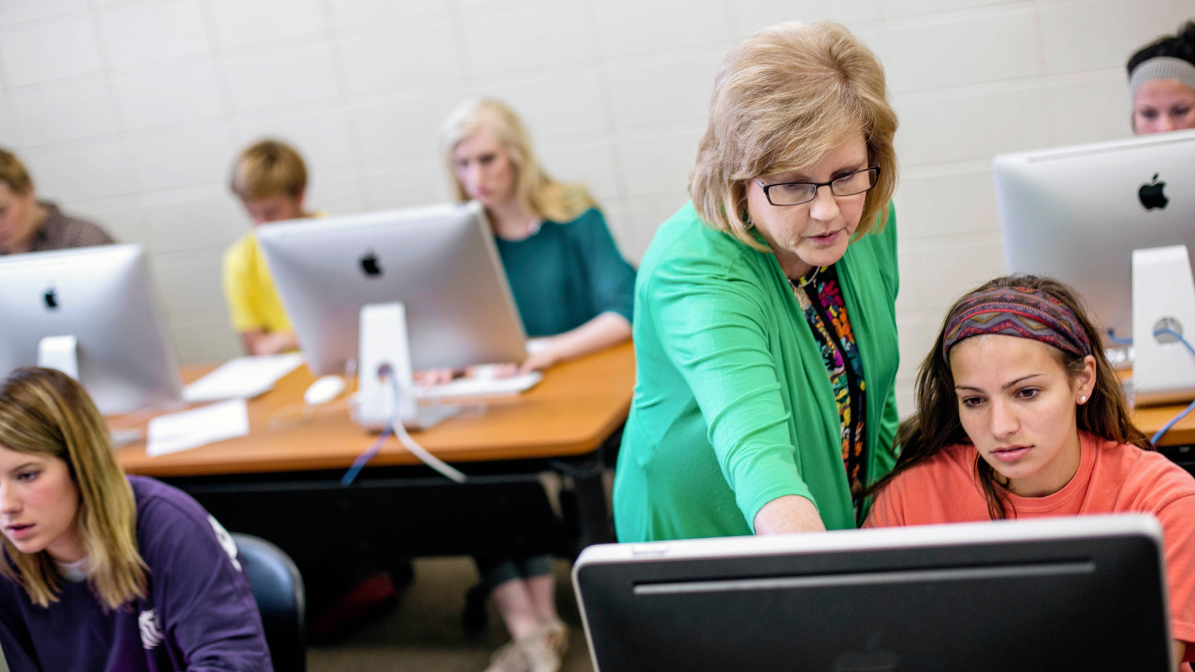 Professor working with students in classroom